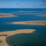 2025-01-21_CJFClimate_NorthwestPassage_001 Aerial view of the Northwest Passage showing blue sky, blue ocean, and brown land. No polar ice is visible.
